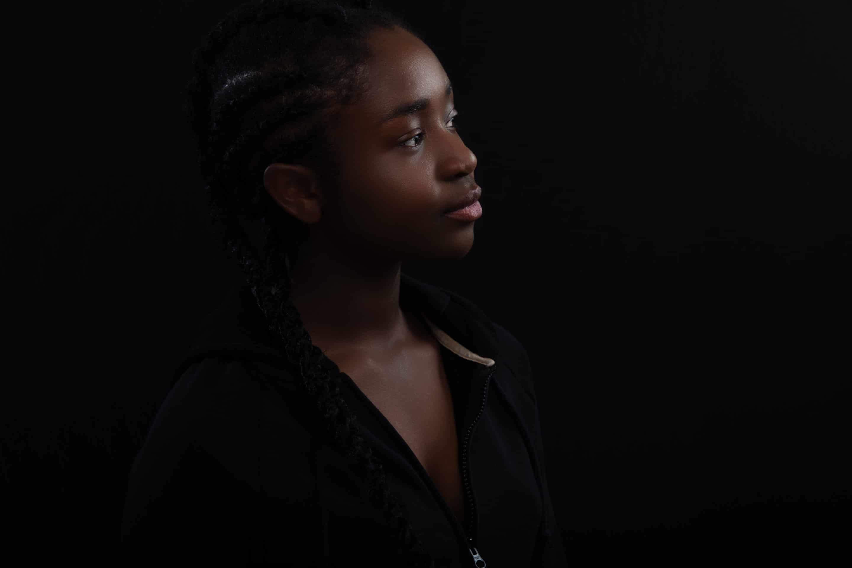 Confident and happy Black Female Model Looking Away Against Black Background